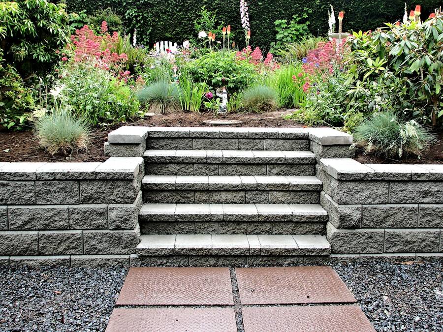 Stone masonry steps and retaining wall in a landscaped garden bed